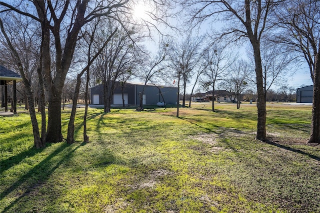 view of yard featuring a garage and an outbuilding