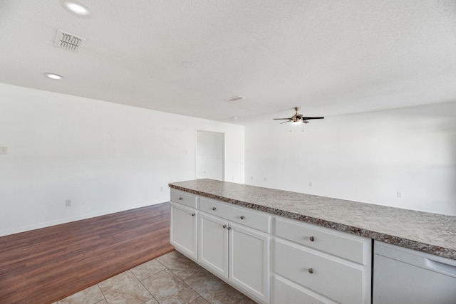 kitchen featuring ceiling fan, a textured ceiling, light hardwood / wood-style floors, and white cabinets