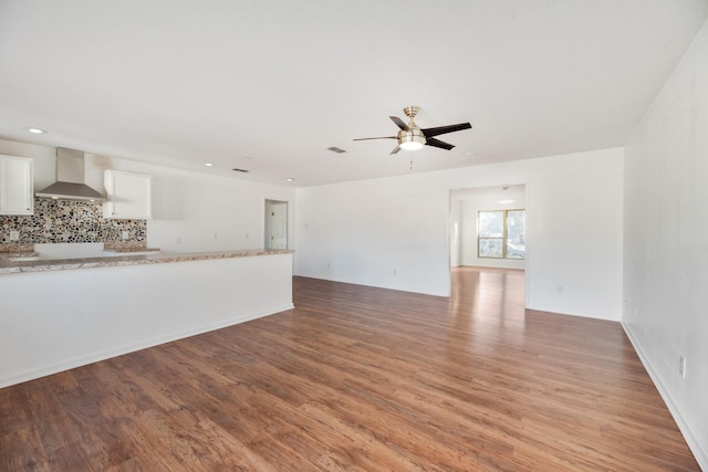 unfurnished living room with ceiling fan and light wood-type flooring