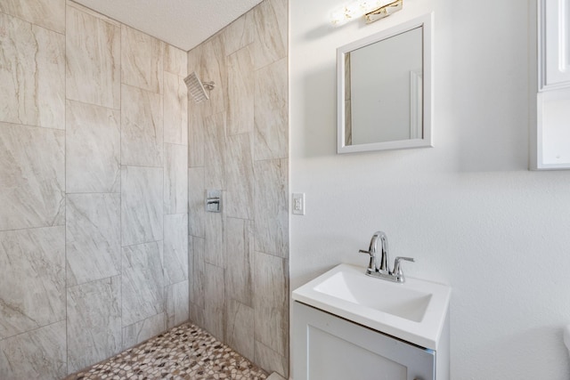 bathroom with vanity and a tile shower