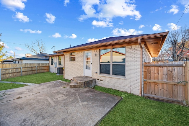 rear view of house with a yard, a patio, and central air condition unit