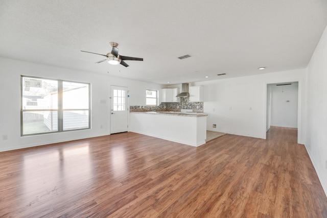 unfurnished living room featuring wood-type flooring and ceiling fan