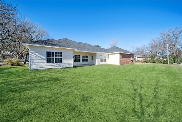 rear view of property featuring a yard