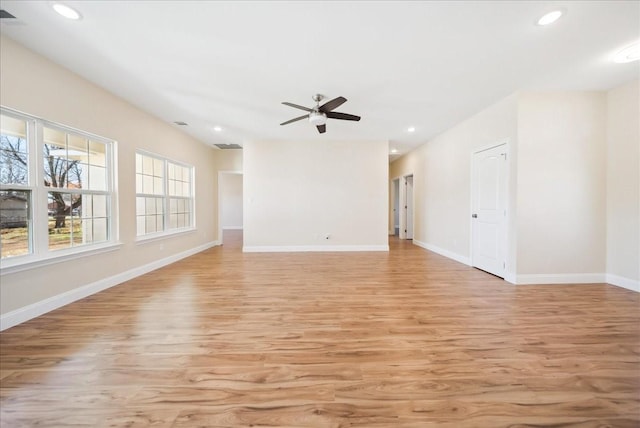 spare room with light wood-type flooring and ceiling fan