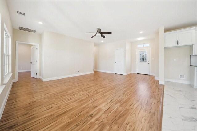 unfurnished living room with ceiling fan, plenty of natural light, and light wood-type flooring