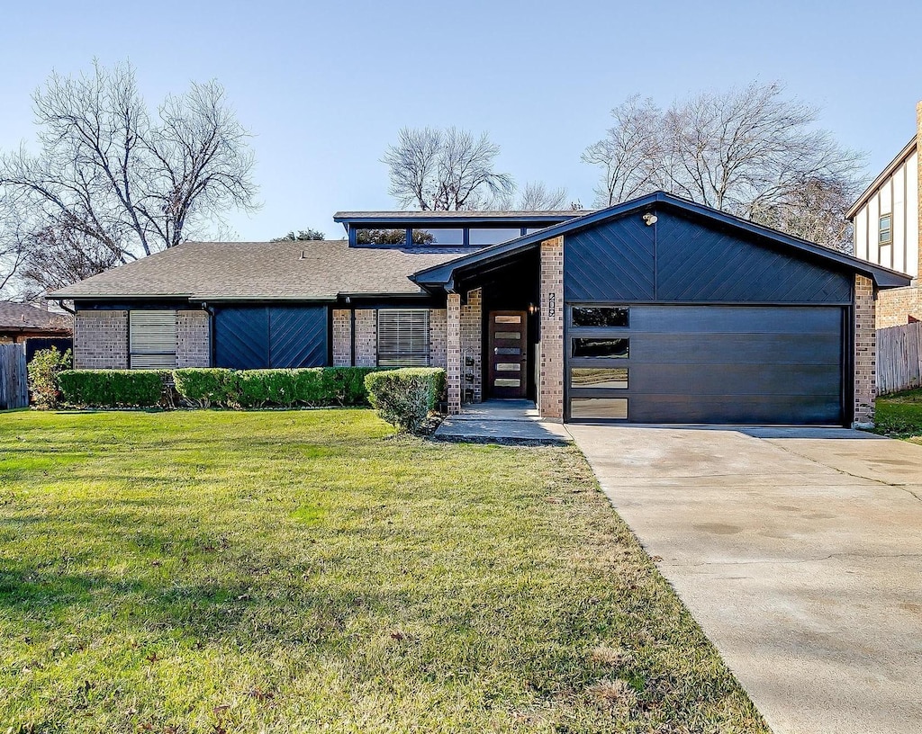 view of front of home with a garage and a front lawn