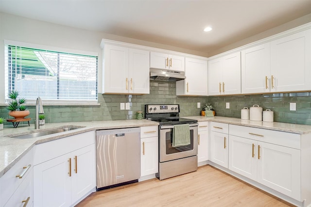 kitchen featuring light stone countertops, stainless steel appliances, sink, light hardwood / wood-style floors, and white cabinetry