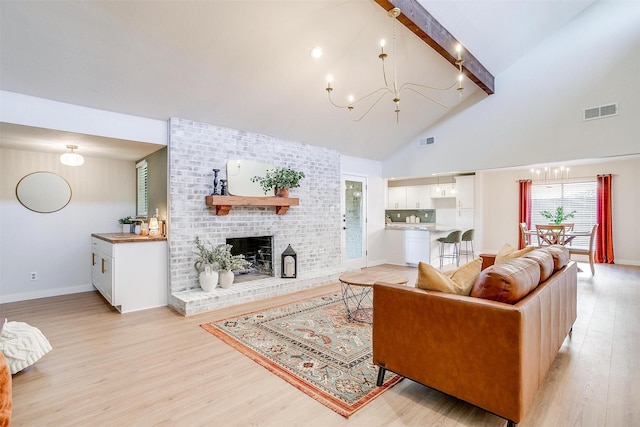 living room featuring beamed ceiling, a fireplace, high vaulted ceiling, and light hardwood / wood-style flooring