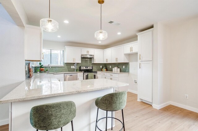 kitchen with kitchen peninsula, white cabinetry, stainless steel appliances, and decorative light fixtures