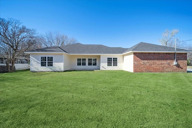 rear view of house featuring a lawn