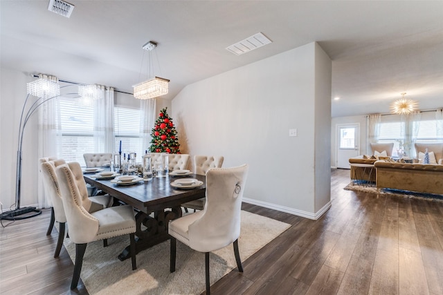 dining space with a notable chandelier and dark wood-type flooring