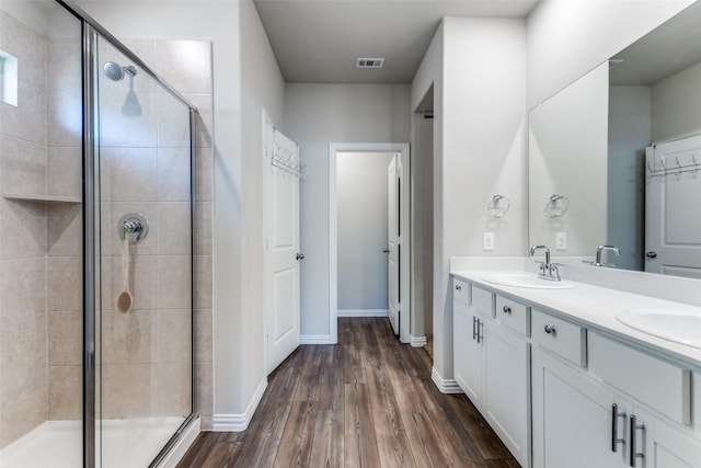 bathroom with vanity, wood-type flooring, and a shower with shower door