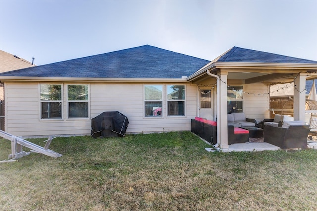 rear view of house with outdoor lounge area, a patio area, and a lawn