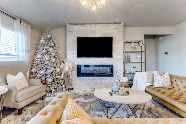 living room with lofted ceiling, a fireplace, and a chandelier