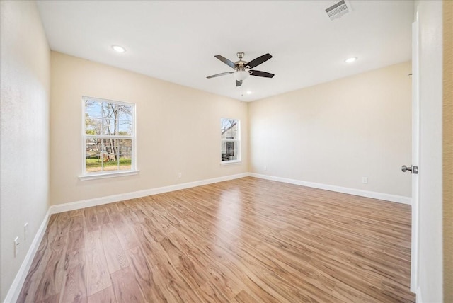 empty room with ceiling fan and light hardwood / wood-style flooring