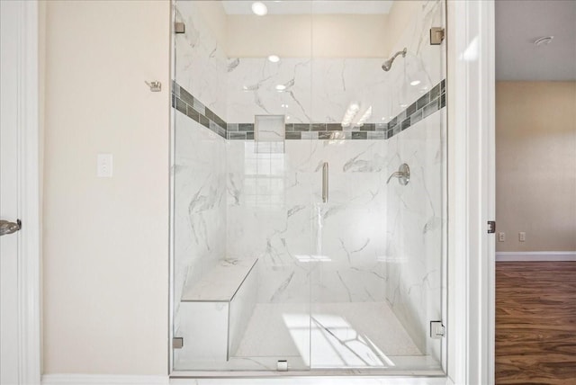 bathroom with wood-type flooring and an enclosed shower