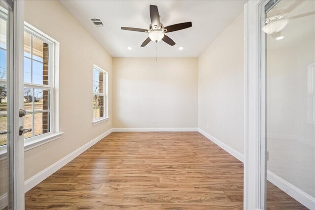 unfurnished room featuring ceiling fan, plenty of natural light, and light wood-type flooring