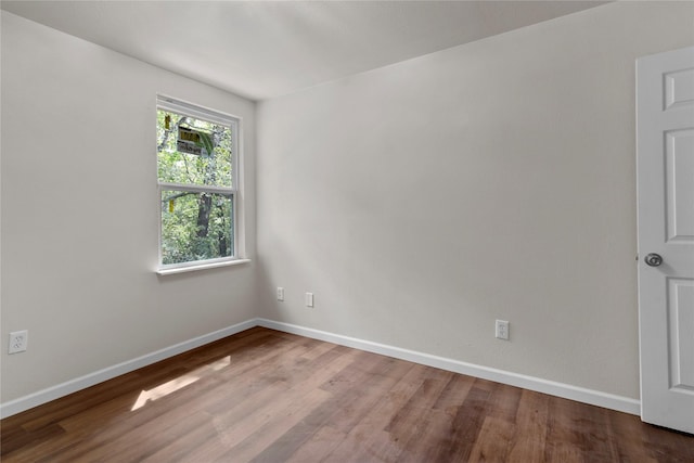 unfurnished room with hardwood / wood-style flooring