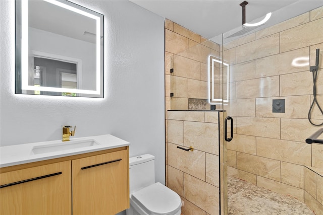 bathroom featuring vanity, toilet, and a shower with door