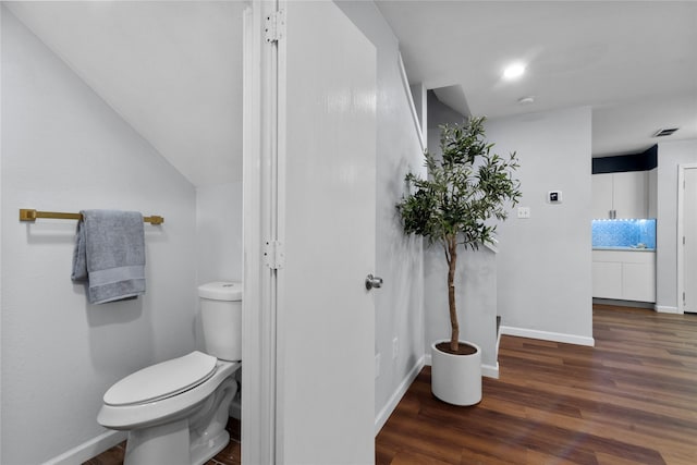 bathroom with hardwood / wood-style flooring and toilet