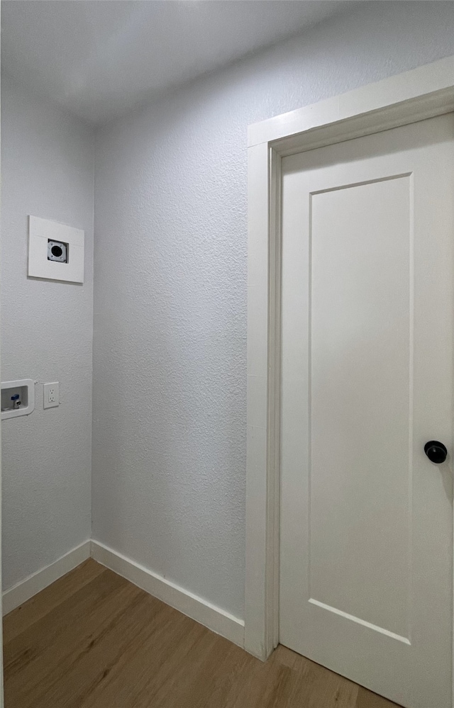 interior space with wood-type flooring, hookup for an electric dryer, and hookup for a washing machine