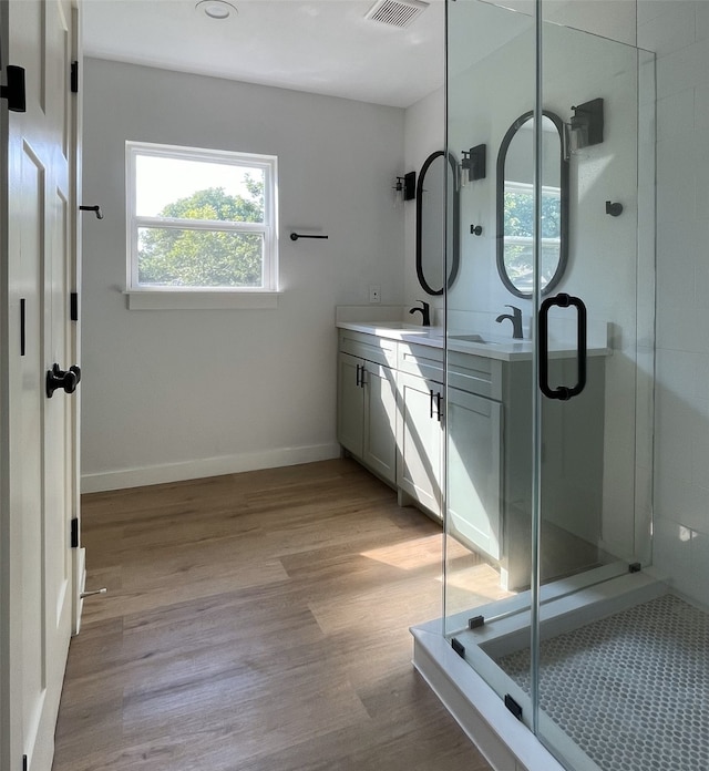 bathroom with vanity, wood-type flooring, and a shower with door