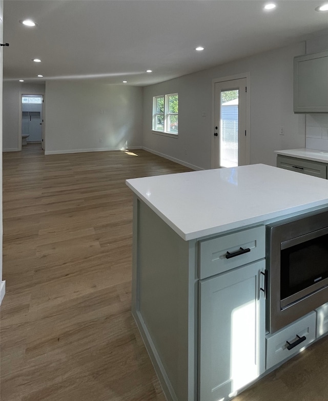 kitchen featuring a center island, gray cabinetry, and light hardwood / wood-style flooring