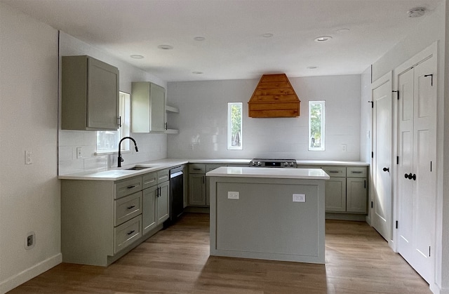 kitchen featuring premium range hood, sink, a center island, light hardwood / wood-style flooring, and backsplash