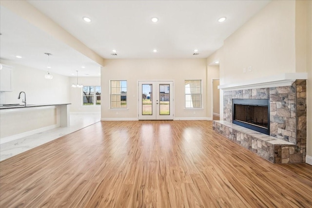 unfurnished living room with sink, a fireplace, and light wood-type flooring