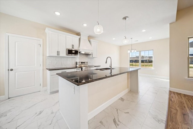 kitchen with white cabinetry, sink, a center island with sink, custom exhaust hood, and appliances with stainless steel finishes