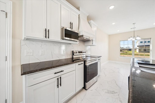 kitchen featuring white cabinets, hanging light fixtures, dark stone countertops, appliances with stainless steel finishes, and a notable chandelier