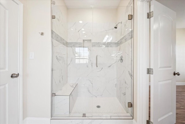 bathroom with a shower with door and hardwood / wood-style flooring