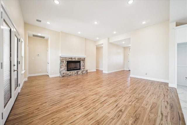 unfurnished living room with a fireplace and light wood-type flooring