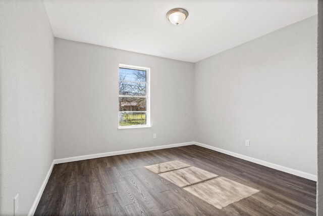 unfurnished room with dark wood-type flooring