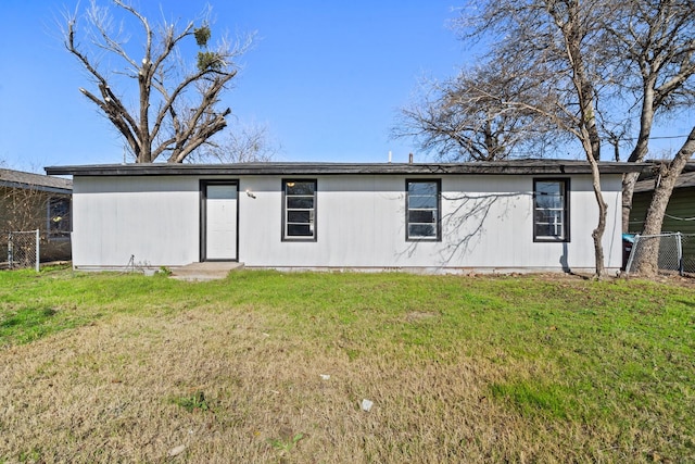 rear view of house featuring a lawn