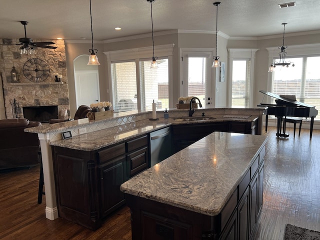 kitchen with dishwasher, sink, an island with sink, and decorative light fixtures