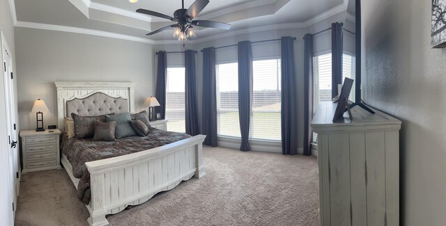 bedroom featuring ceiling fan, light colored carpet, a tray ceiling, and multiple windows