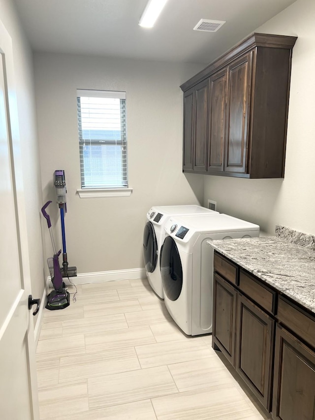 washroom with washer and clothes dryer and cabinets