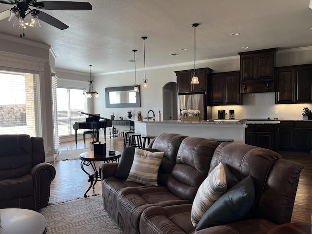 living room featuring ceiling fan, ornamental molding, sink, and light hardwood / wood-style flooring