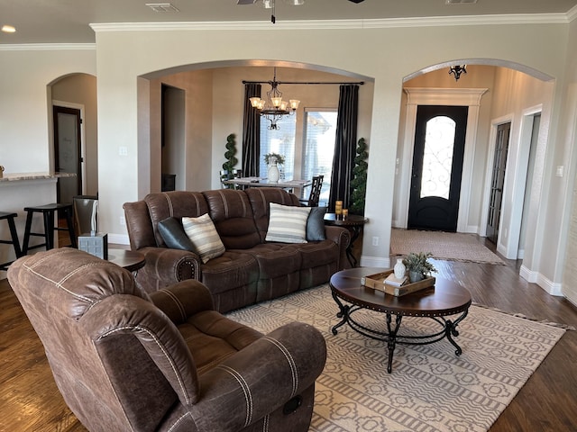 living room with hardwood / wood-style floors, ceiling fan with notable chandelier, and crown molding