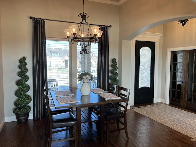 dining area featuring a chandelier, french doors, and dark wood-type flooring