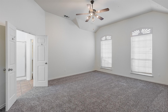 carpeted spare room featuring ceiling fan and lofted ceiling