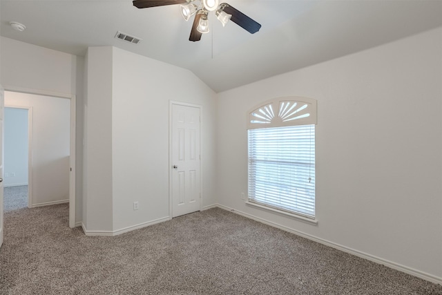 spare room with carpet flooring, vaulted ceiling, and ceiling fan