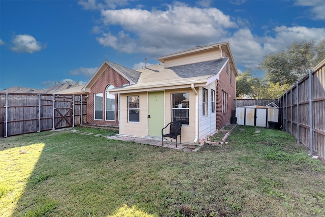 rear view of property with a lawn and a shed