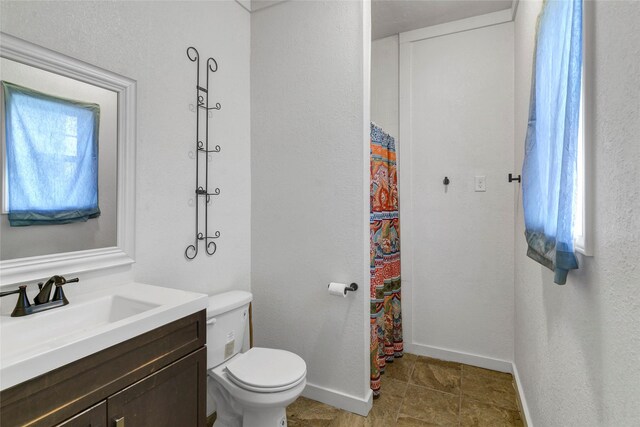 bathroom with a wealth of natural light, vanity, a shower with shower curtain, and toilet