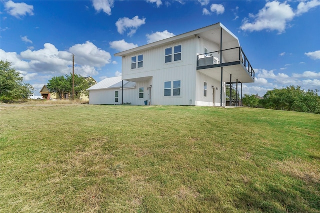 rear view of house with a balcony and a yard