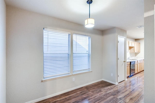 unfurnished dining area with a sink, wood finished floors, visible vents, and baseboards