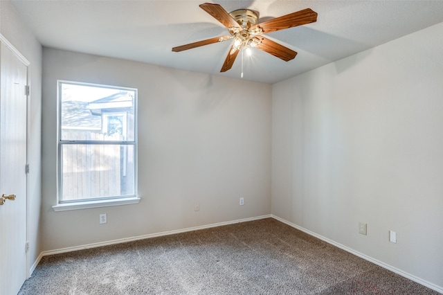 carpeted empty room with ceiling fan and baseboards