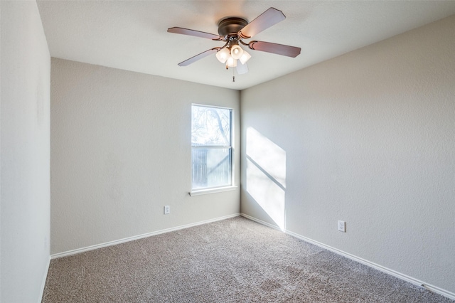 empty room featuring carpet floors, baseboards, and a ceiling fan