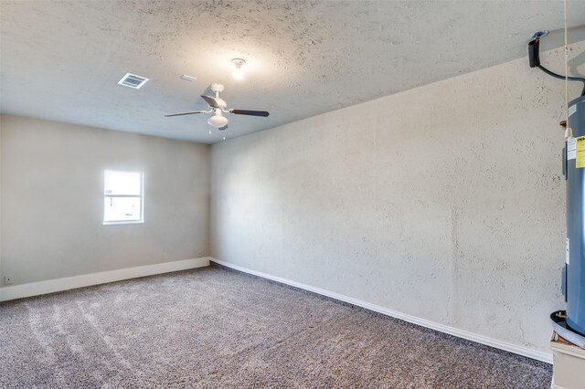 carpeted empty room with visible vents, ceiling fan, a textured ceiling, and baseboards